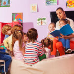 preschool kids sitting in group listening to teacher read